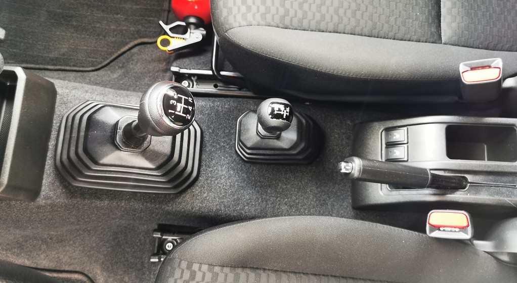 Drążek zmiany biegów i mniejsza dźwignia do sterowania napędem 4x4 i reduktorem