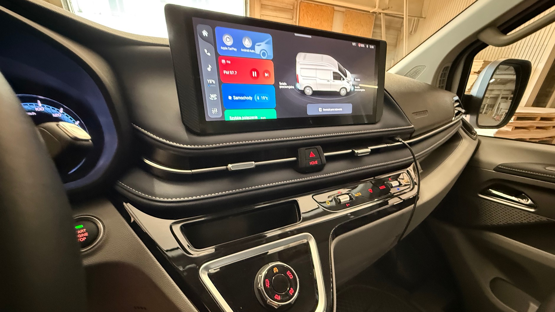 Maxus e-Deliver 7 AWD: w elektrycznej wersji ma wysuniętym "półwyspie" deski rozdzielczej jest wielkie pokrętło – postawiono tu cokolwiek, by zająć miejsce, które w spalinowej wersji przeznaczonej jest a lewarek skrzyni biegów. A lepiej byłoby to zlikwidować, po pasażer dokłądnie trafia w to kolanem