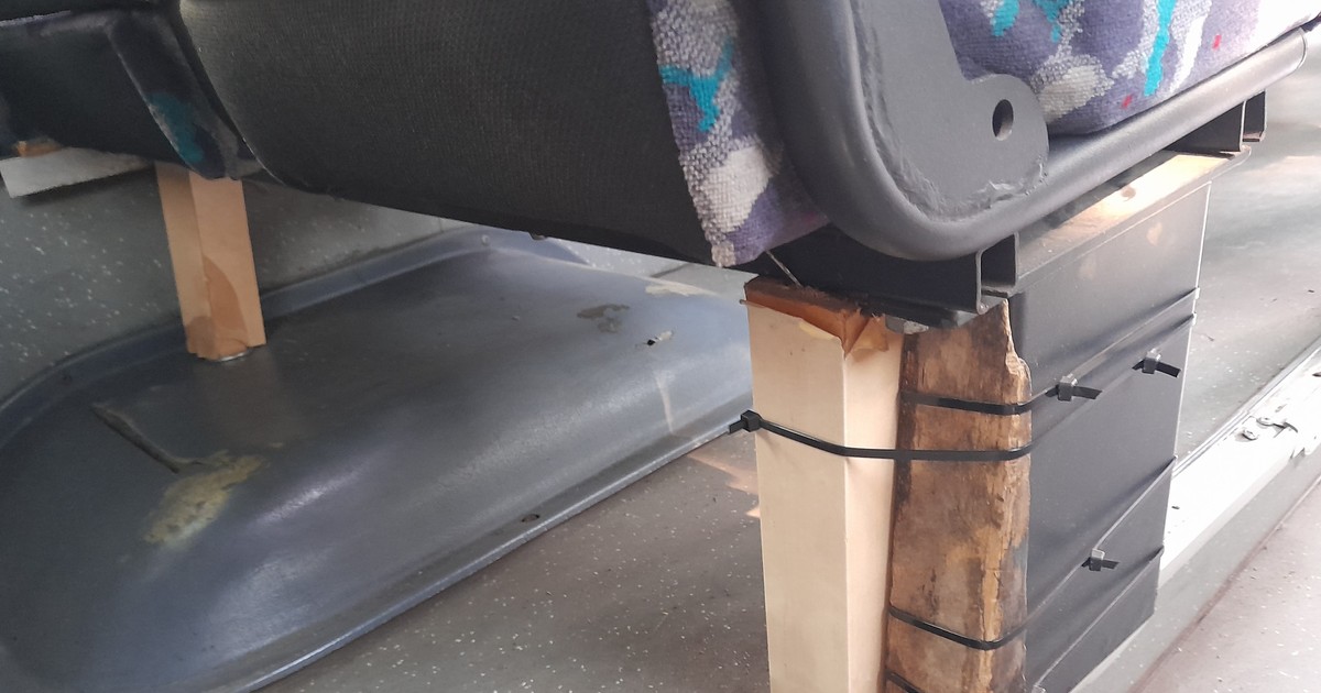 Autobus z fotelami na drewnianych klockach i z pękniętą felgą