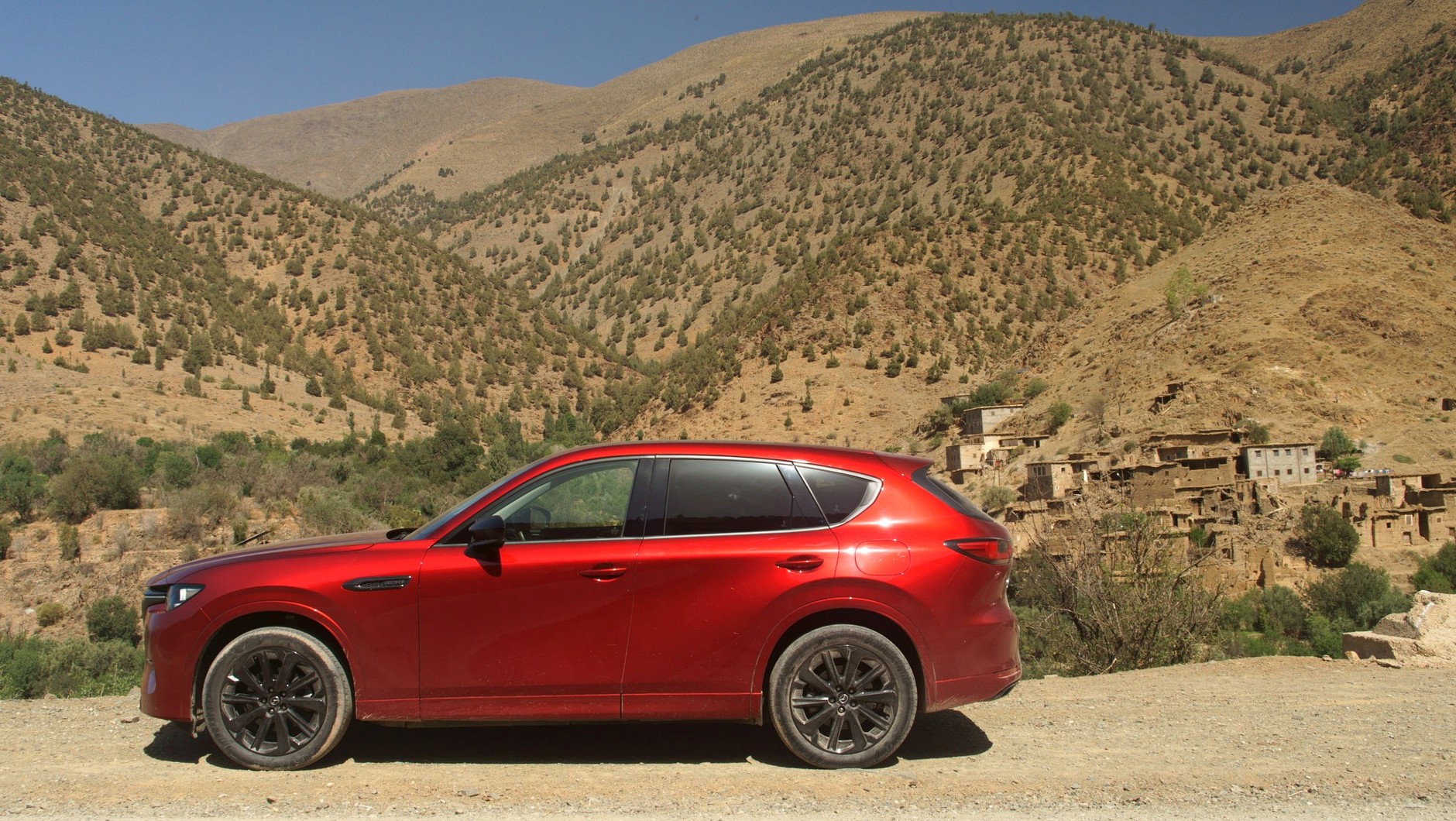 Mazda CX-60 na tle zburzonej górskiej osady