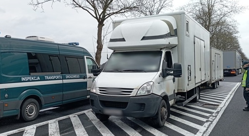 Radiowóz ITD, zatrzymany do kontroli drogowej zespół pojazdów i stojący obok inspektor ITD