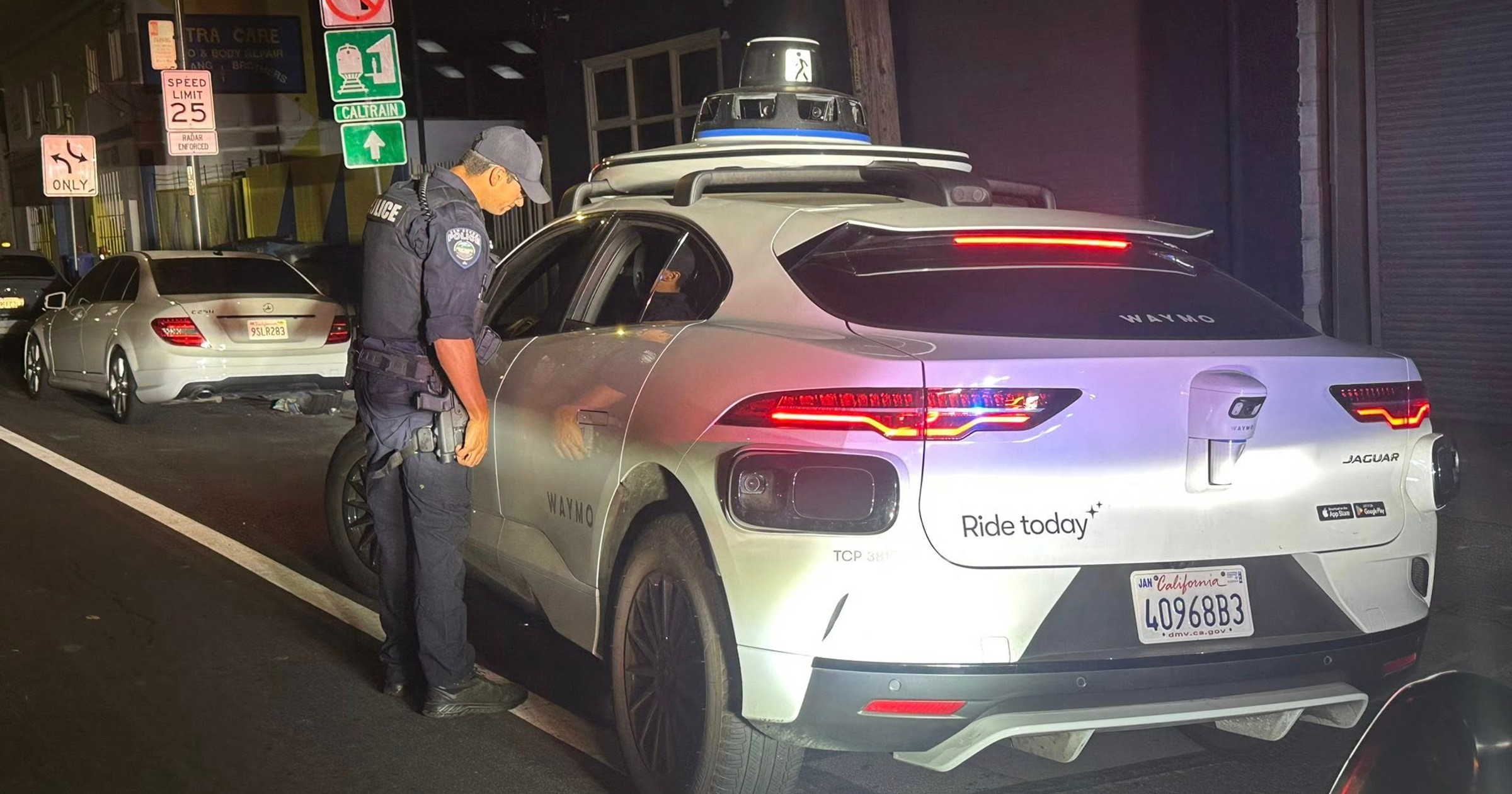 Policjant zagląda do środka samochodu autonomicznego