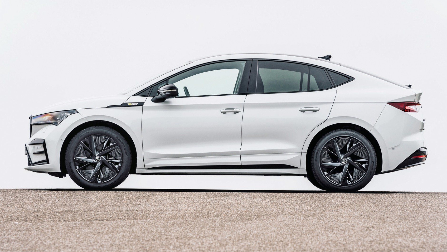 Skoda Enyaq Coupe 2022 - styliści zrobili, co tylko mogli, żeby załagodzić linie SUV-a i dodać im wdzięk, ale... Niestety, topografia platform elektrycznych jest bezlitosna i te mniej więcej 10 cm grubości baterii w podłodze "widać" po sylwetce. W efekcie auto wygląda zbyt potężnie, żeby skojarzy je z coupe z czasów klasycznej motoryzacji. No ale z drugiej strony - czy pierwsze BMW X6, protoplasta SUV-ów coupe, było zgrabniejsze?