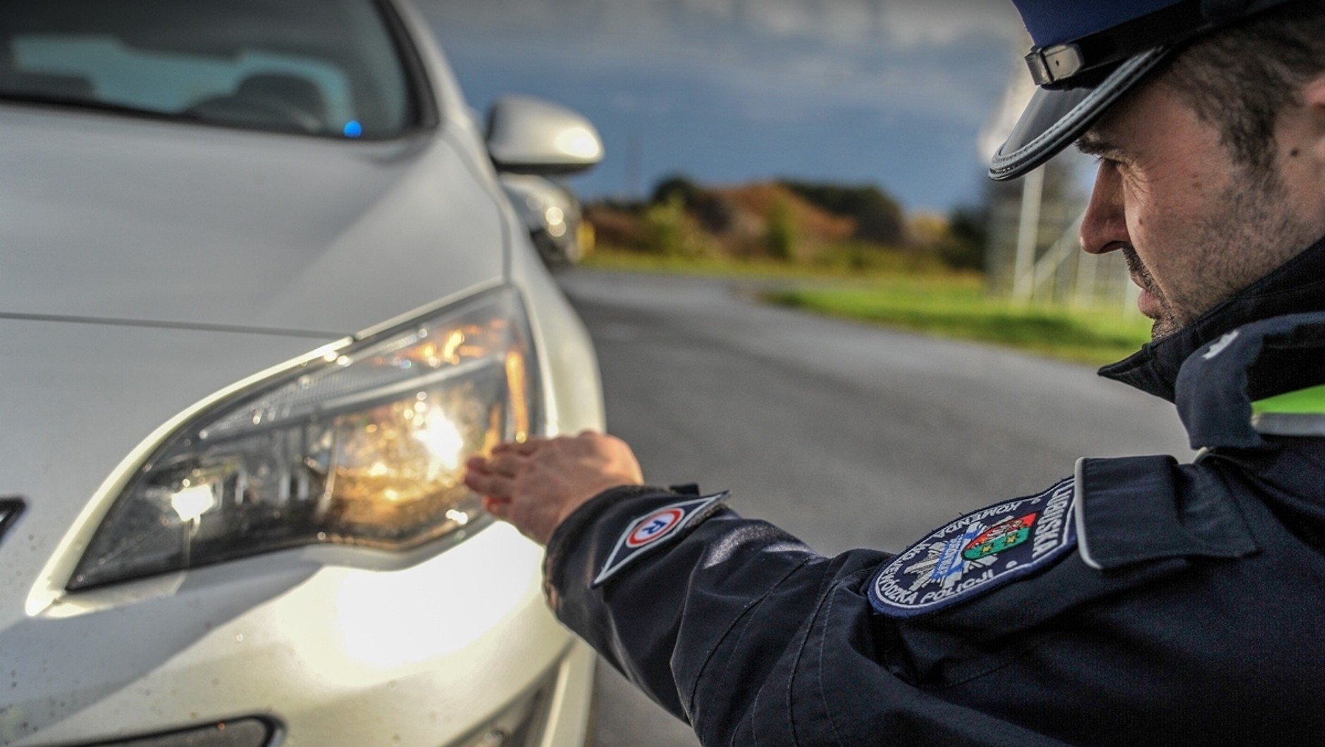 Policjant sprawdza światła podczas kontroli drogowej
