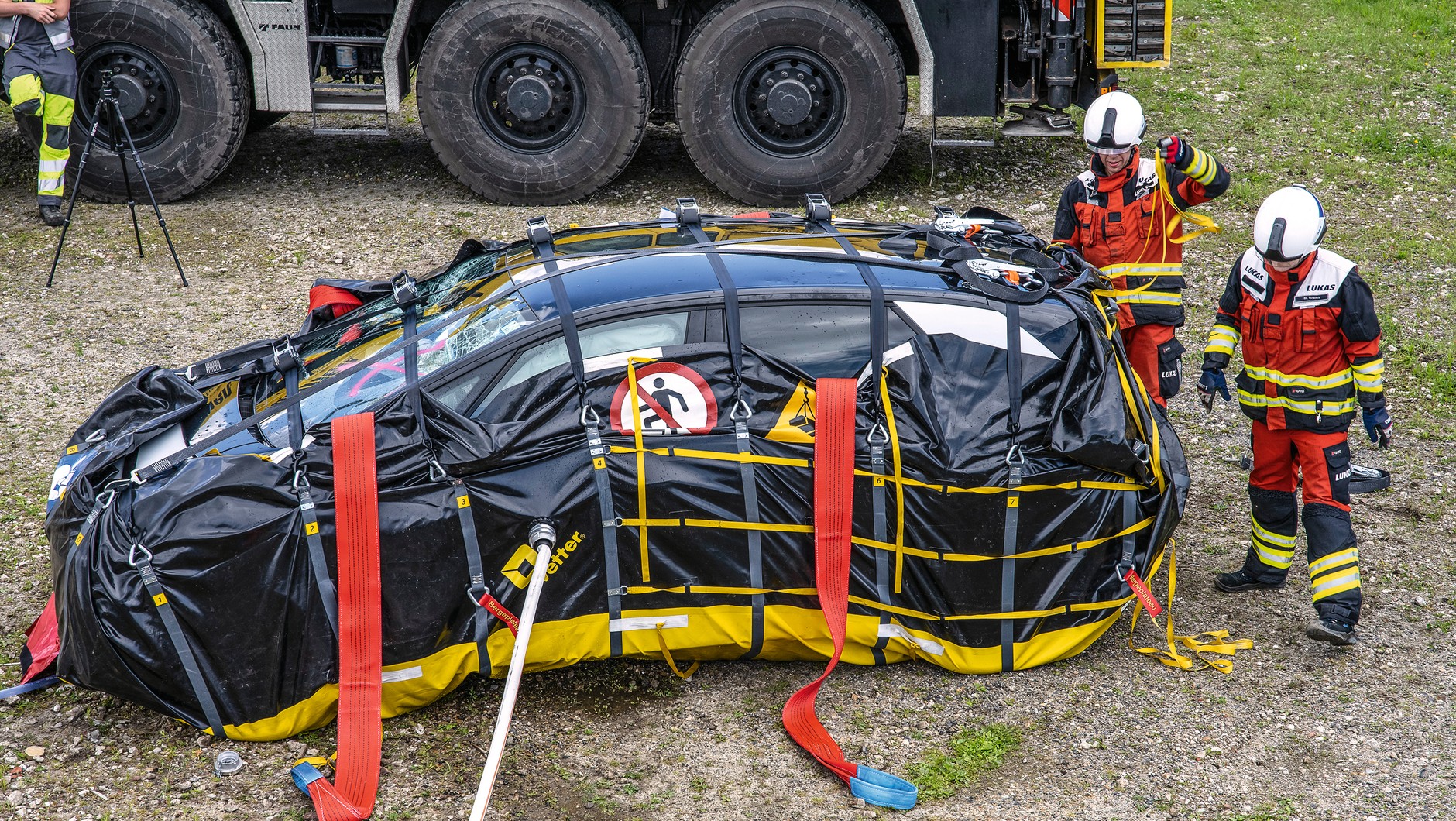 Worek do zabezpieczenia wraku: to kolejna wariacja metody polegającej na zatapianiu nadpalonego wraku auta elektrycznego. Tyle że tu zamiast olbrzymiego metalowego kontenera czy kadzi wykorzystywany jest syntetyczny worek, do którego strażacy pakują wstępnie ugaszone auto. Zestaw jest więc łatwiejszy w transporcie, zajmuje mniej miejsca, a do wypełnienia worka dopasowującego się do rzeczywistych gabarytów auta potrzeba znacznie mniej wody niż przy standardowym topieniu wraku. Tak zapakowane nadpalone auto można bez obaw postawić przy innych wrakach.