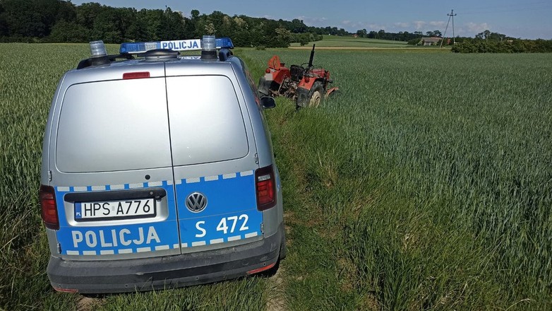 Radiowóz i traktor w polu