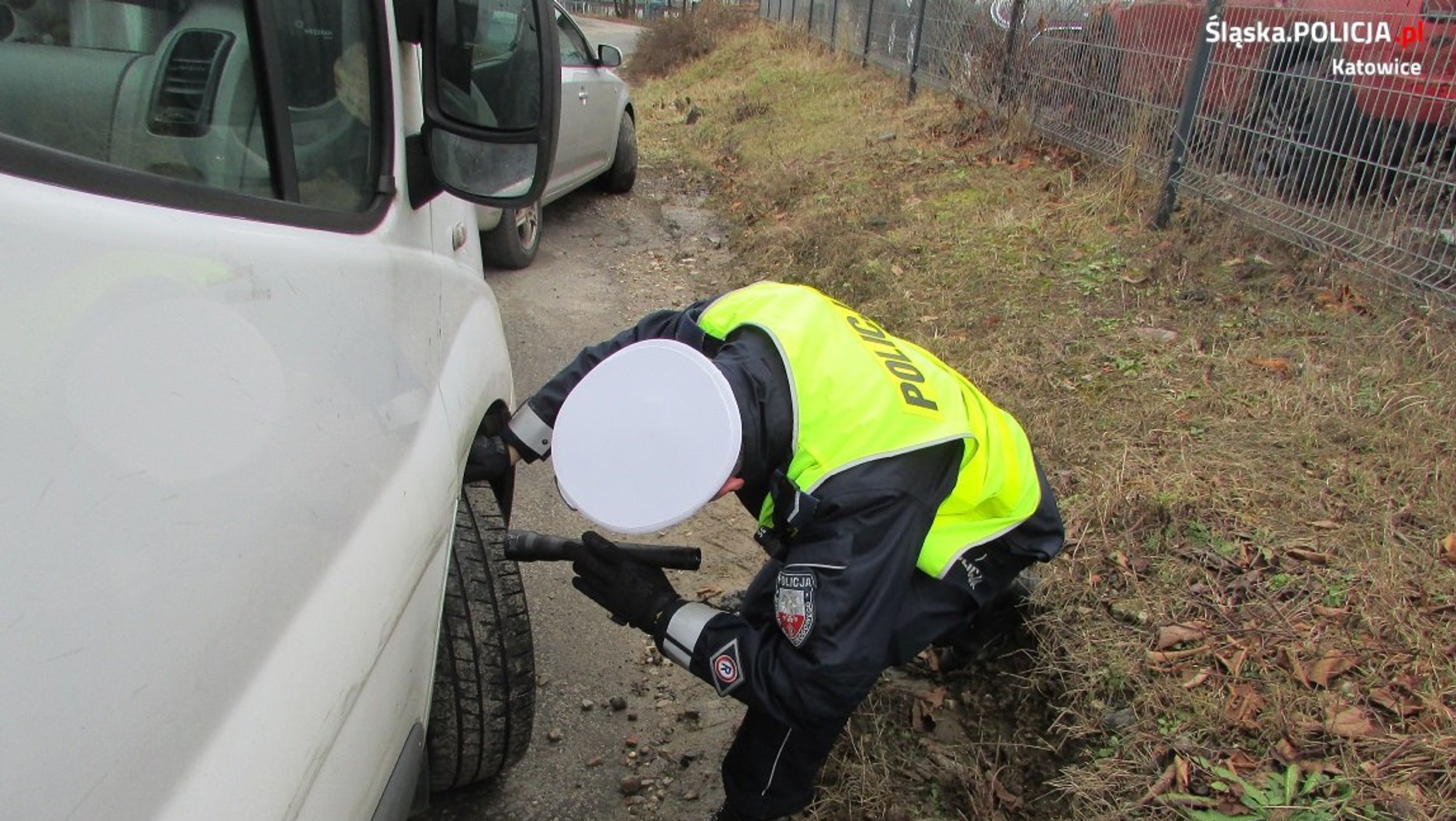 policjant sprawdzający ogumienie