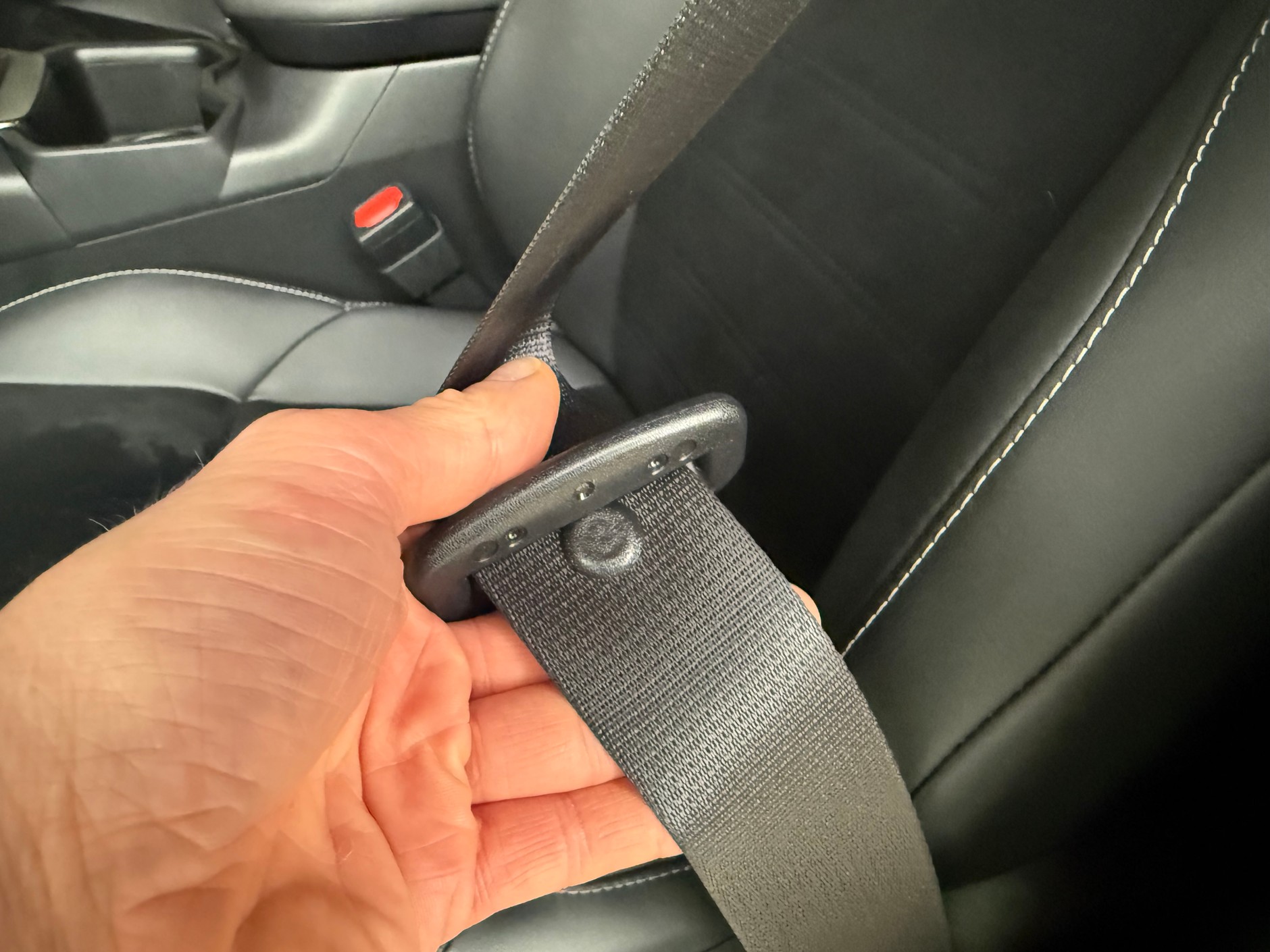 Guzik na pasie bezpieczeństwa zapobiega zsuwaniu się&nbsp;klamry