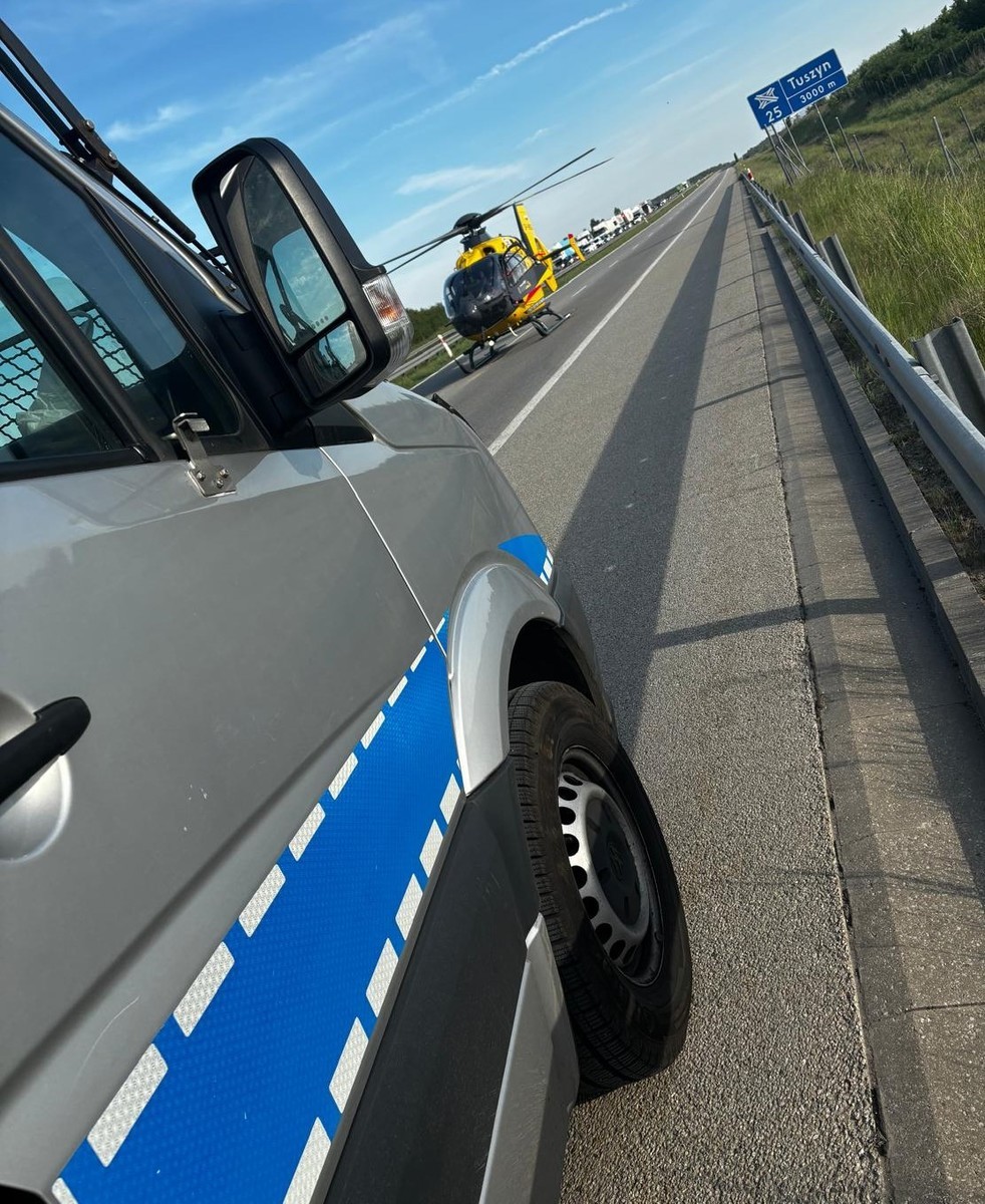 Policyjny radiowóz, a w tle śmigłowiec LPR