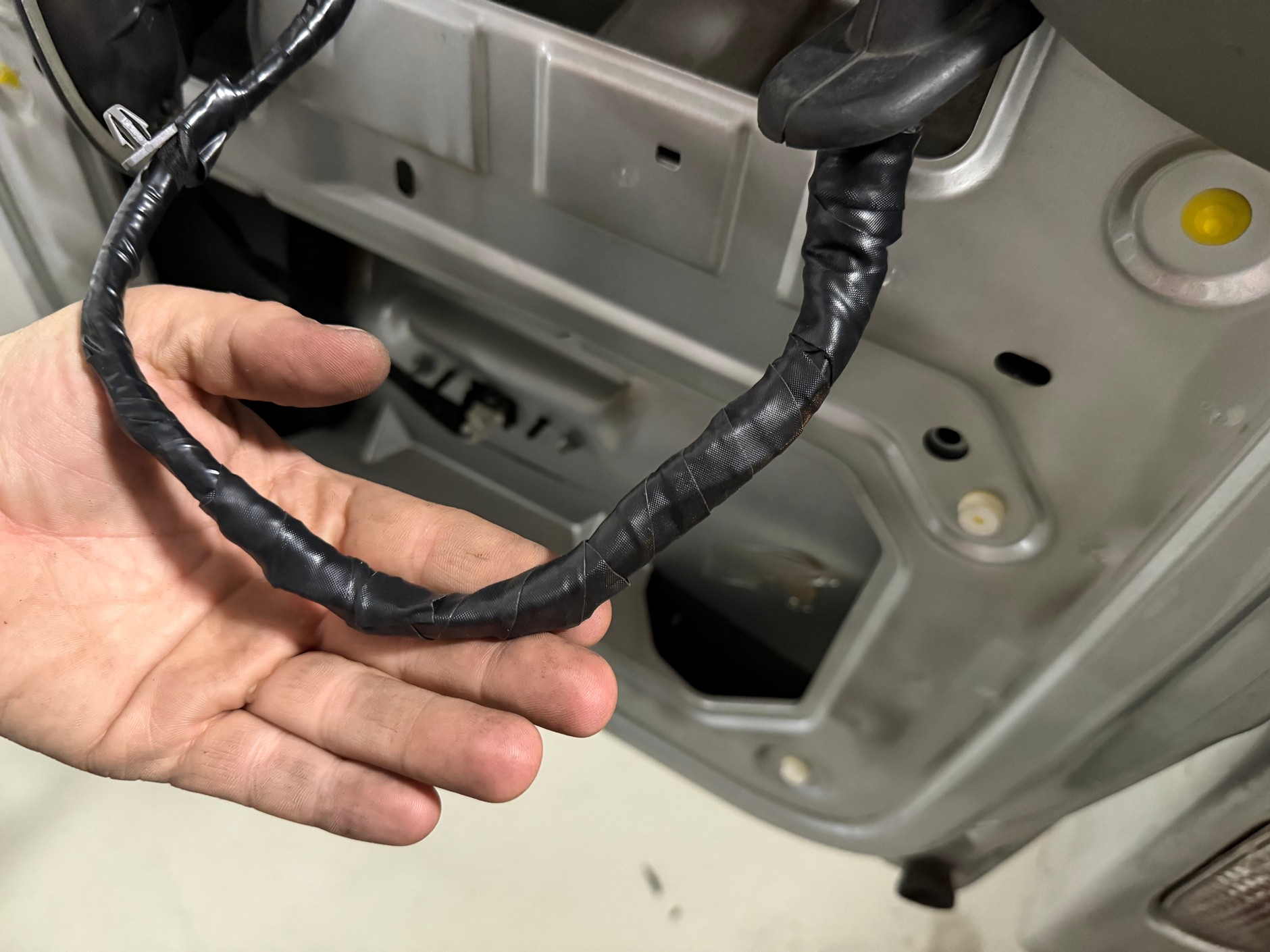 Zmodyfikowaną wiązkę przewodów umieszczoną w drzwiach dokładnie owinęliśmy taśmą uszczelniająco-izolującą i wpieliśmy w oryginalne mocowania. Lepiej niż fabrycznie!