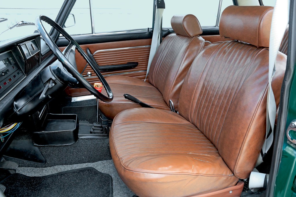 Świetnie utrzymane wnętrze Fiata 125p z brązową tapicerką ze skaju. Samochód ma jeszcze statyczne pasy bezpieczeństwa.