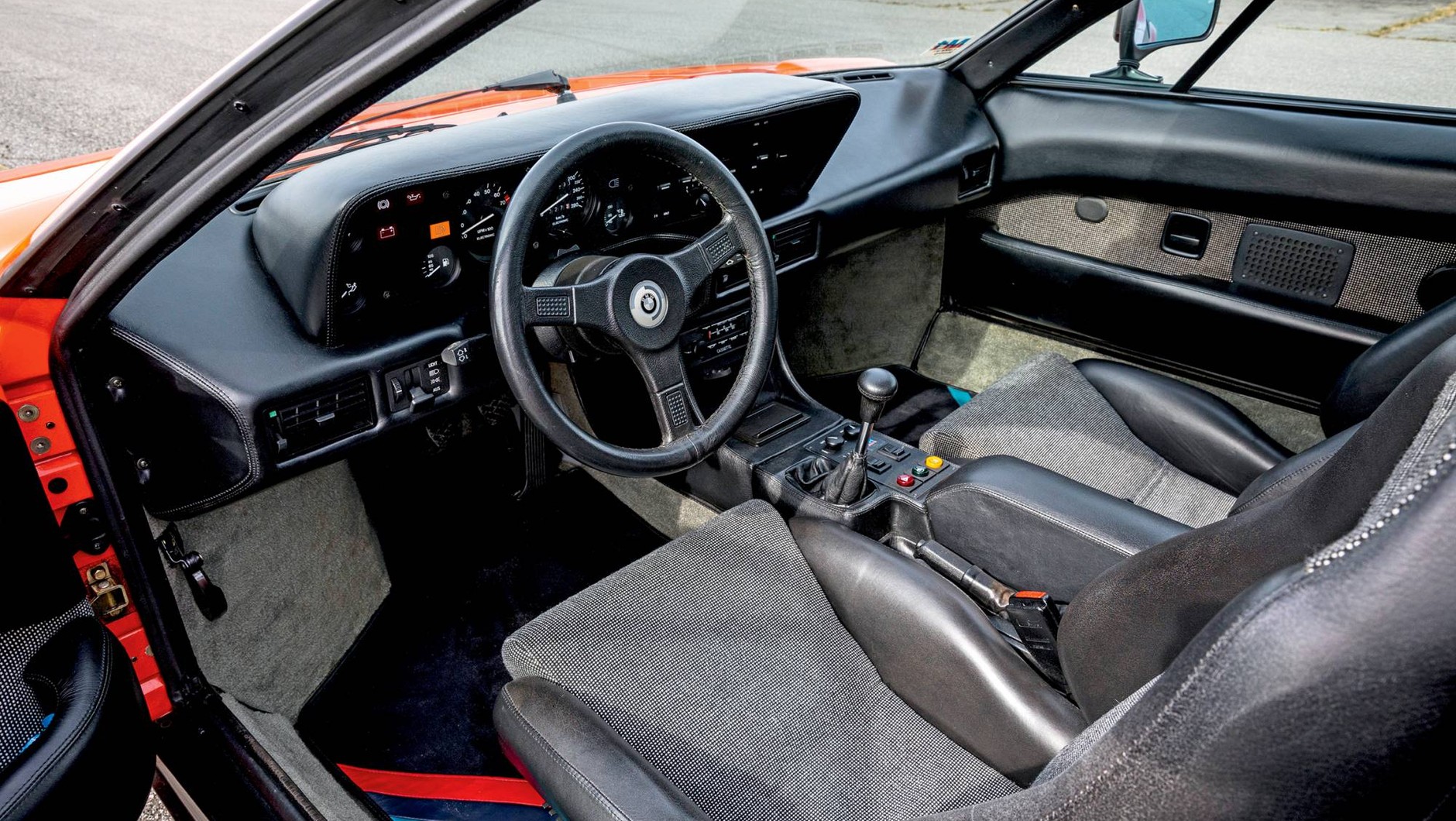 Deskę rozdzielczą obito skórą, ale poza tym we wnętrzu BMW M1 jest raczej skromnie.  Wąskie kubełkowe siedzenia, sterowanie nawiewami z pierwszej serii 3 (E21).
