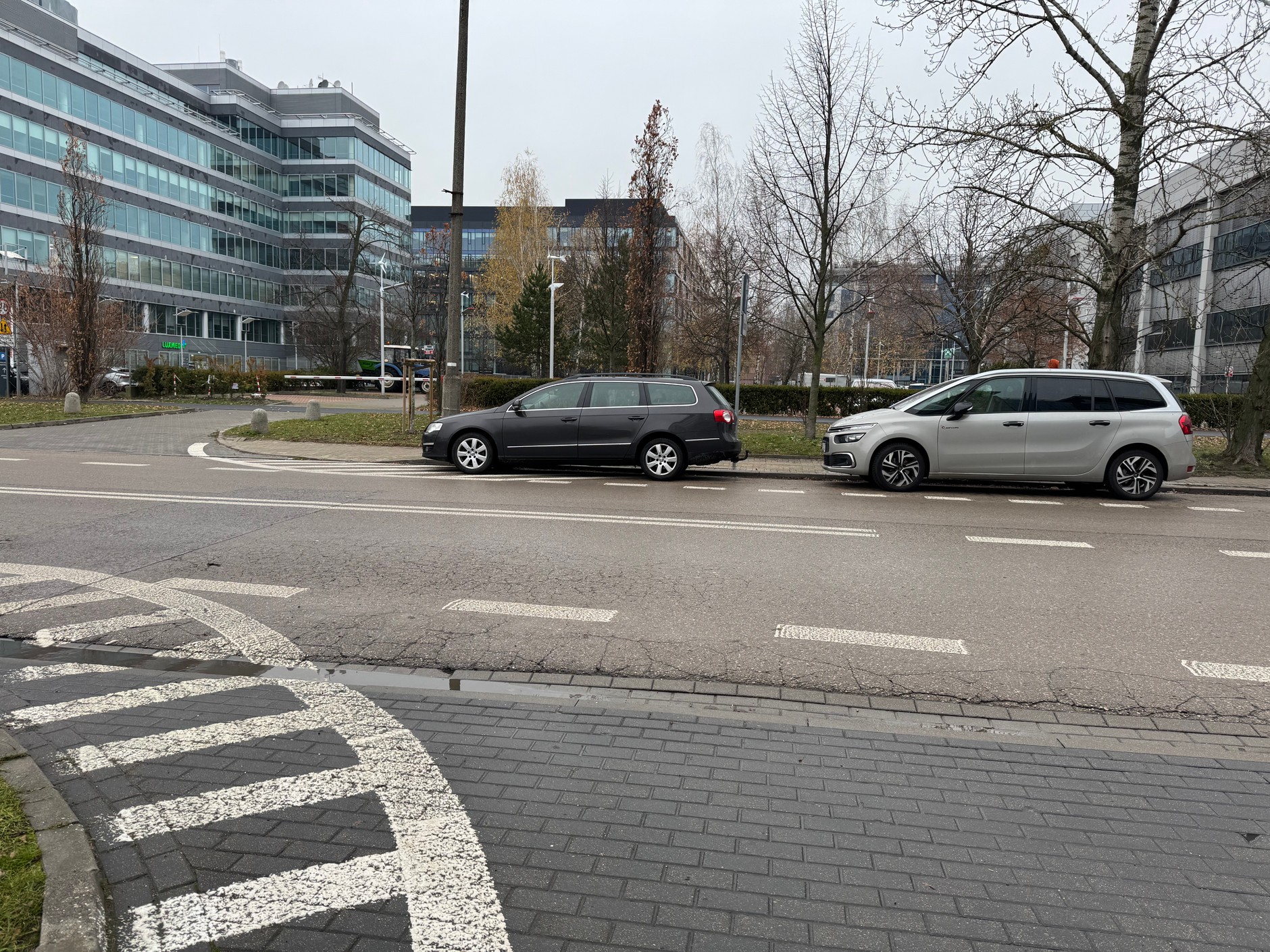 Parkowanie na polu wyłączonym z ruchu jest zabronione, nawet jeśli jest to tylko kawałek samochodu. W tej sytuacji auto na polu ogranicza widoczność dla kierowców wyjeżdżających z drogi poprzecznej