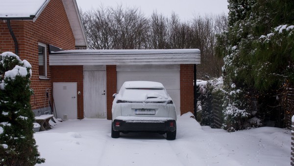Samochód stojący przed garażem zimą