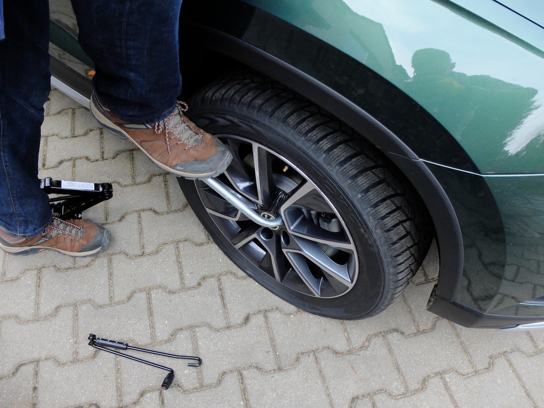 Wymiana koła krok po kroku: teraz poluzuj śruby mocujące koło – zrób to jeszcze przed podniesieniem samochodu na podnośniku. Klucz musi być pewnie nałożony na śrubę.