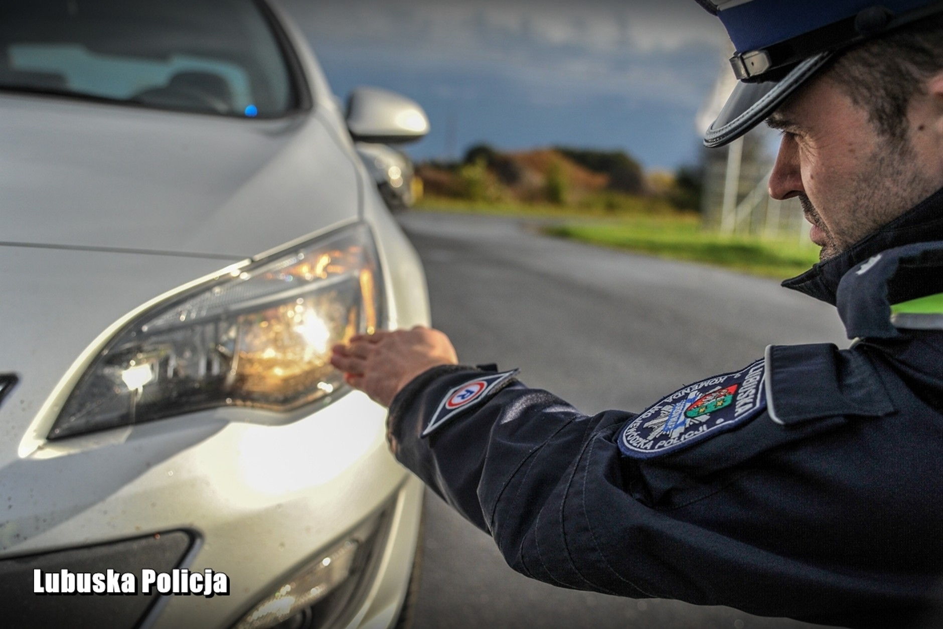 Policjant sprawdza światła podczas kontroli drogowej