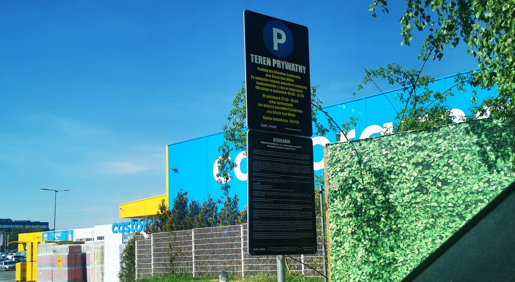 Tabliczka informacyjna i regulamin parkingu. Na wjeździe