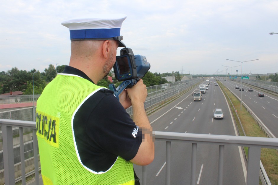 Policjant mierzący odległość między pojazdami w ruchu