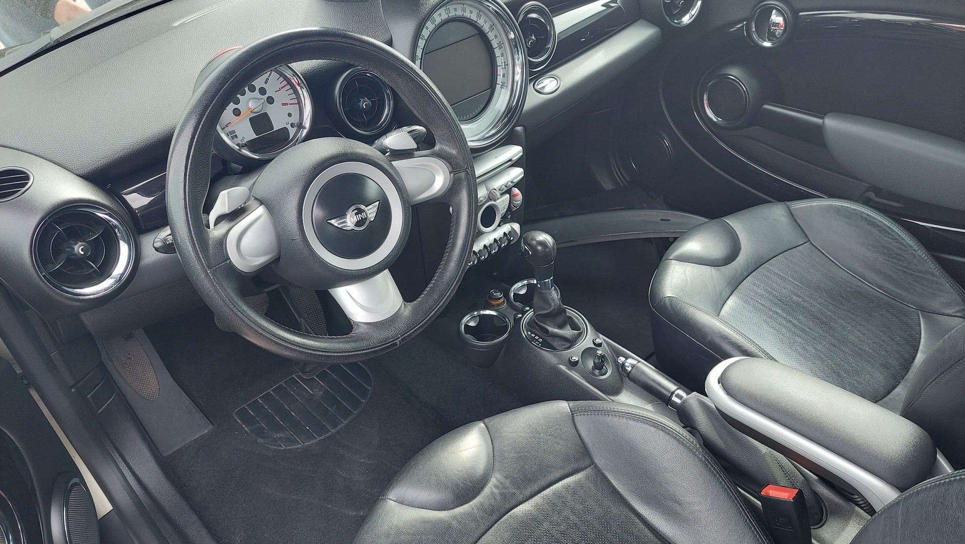 Używany MINI Cooper: kokpit wygląda ładnie na zdjęciach. W rzeczywistości wnętrze jest podmęczone i trzeszczy. Niezłe wyposażenie, choć brak multifunkcyjnej kierownicy