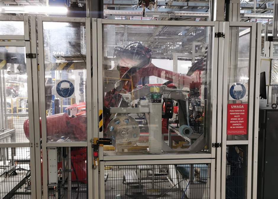 Robot pracujący za tymi drzwiami zajmuje się wklejaniem przednich szyb. Jeszcze niedawno było to robione ręcznie przez pracowników