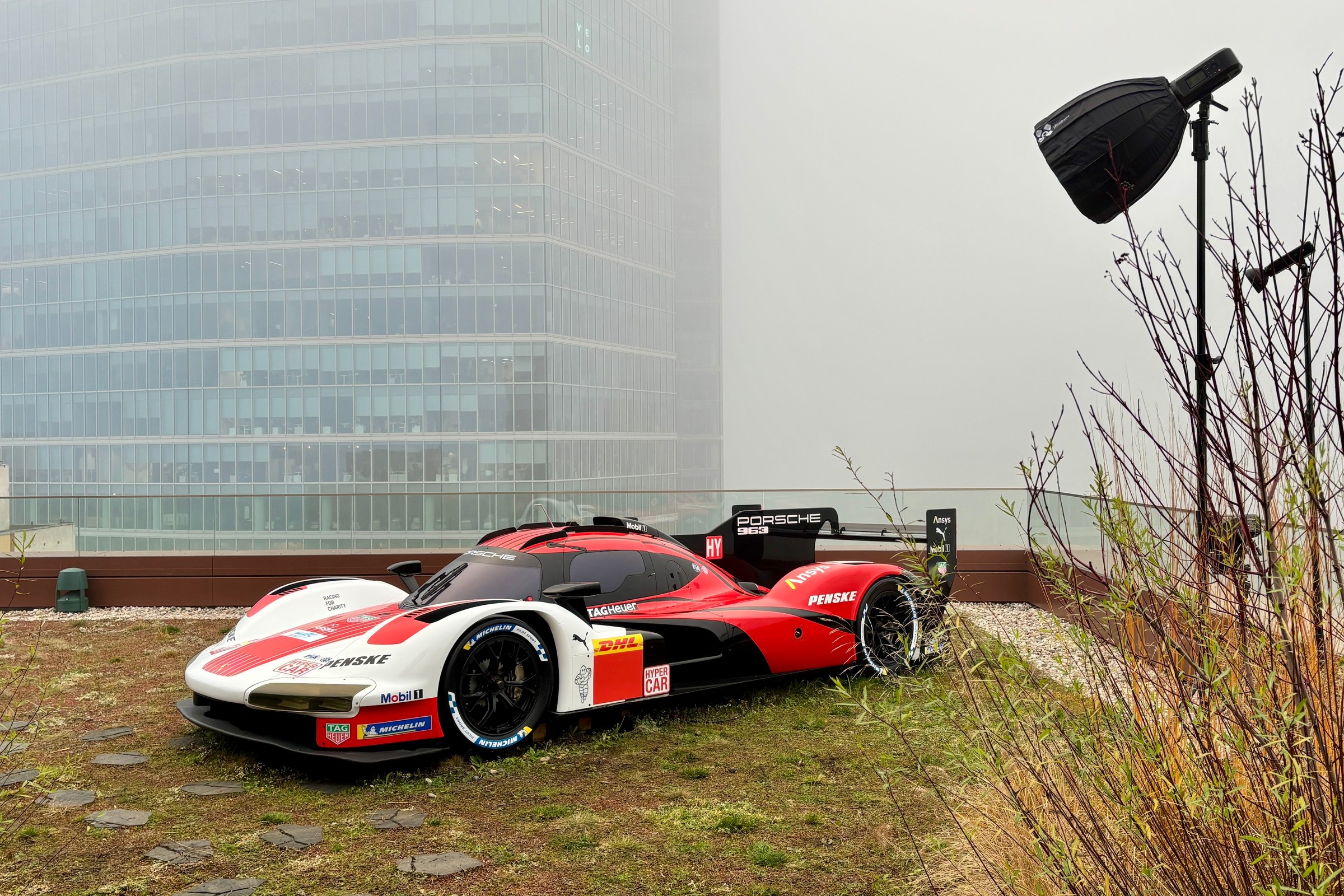 Porsche 963 na dachu warszawskiego biurowca. Nieziemski widok, gdyby nie ta mgła...