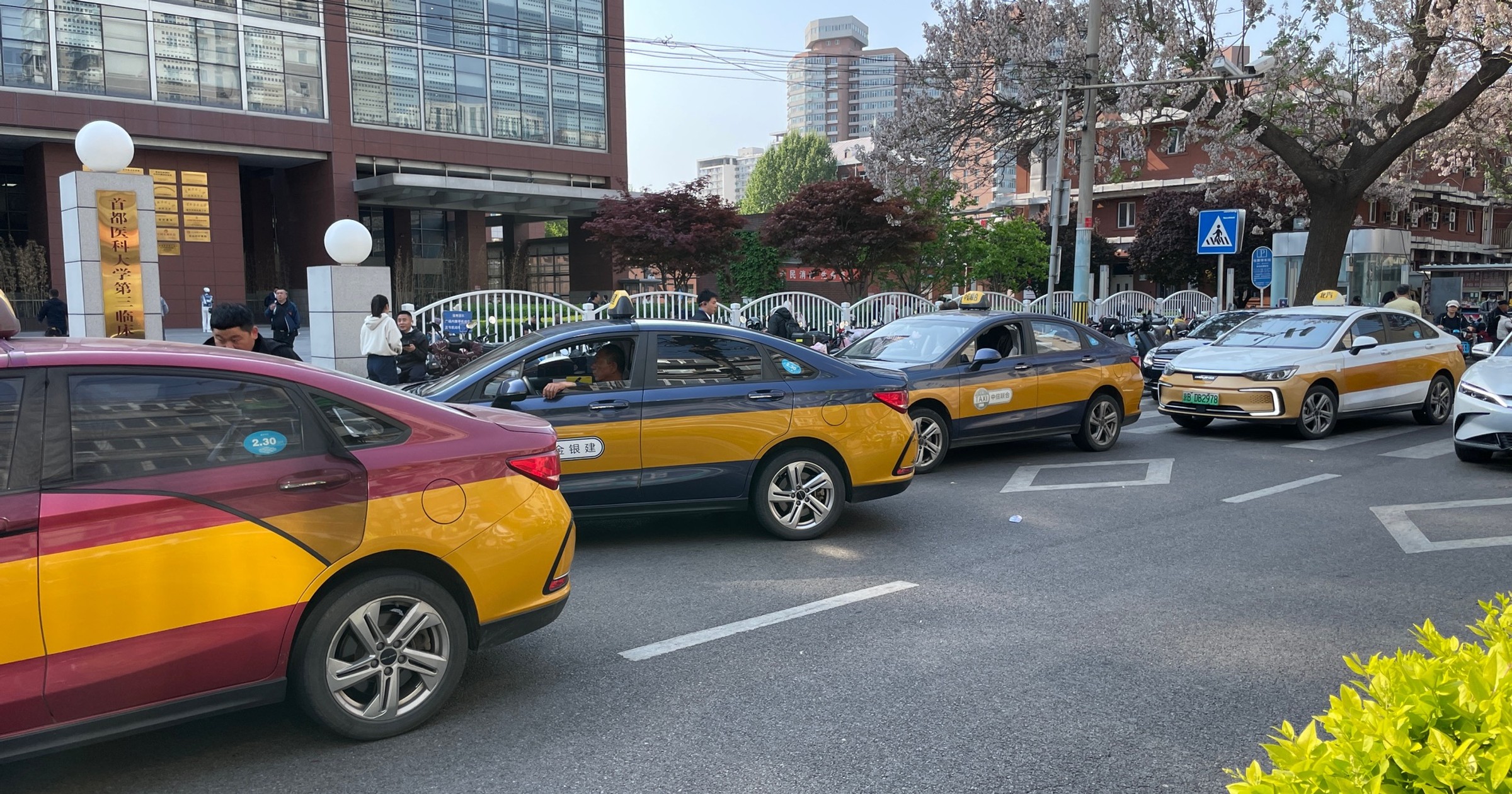 Chińskie taksówki Beijing EU5 (BAIC) przed szpitalem w Pekinie