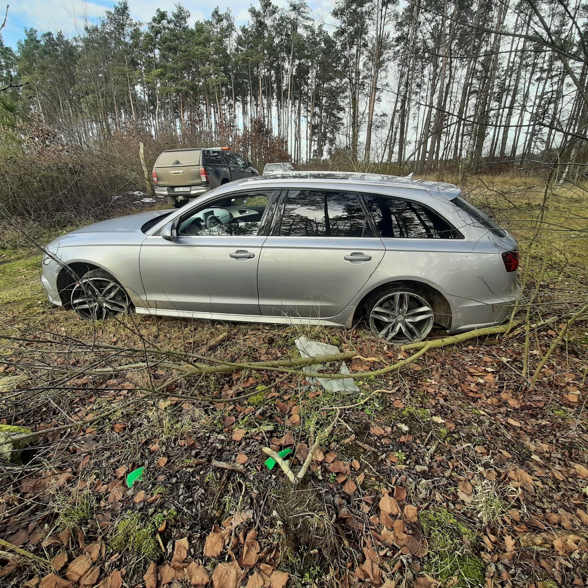 Luksusowe Audi z włączonym silnikiem porzucone w lesie