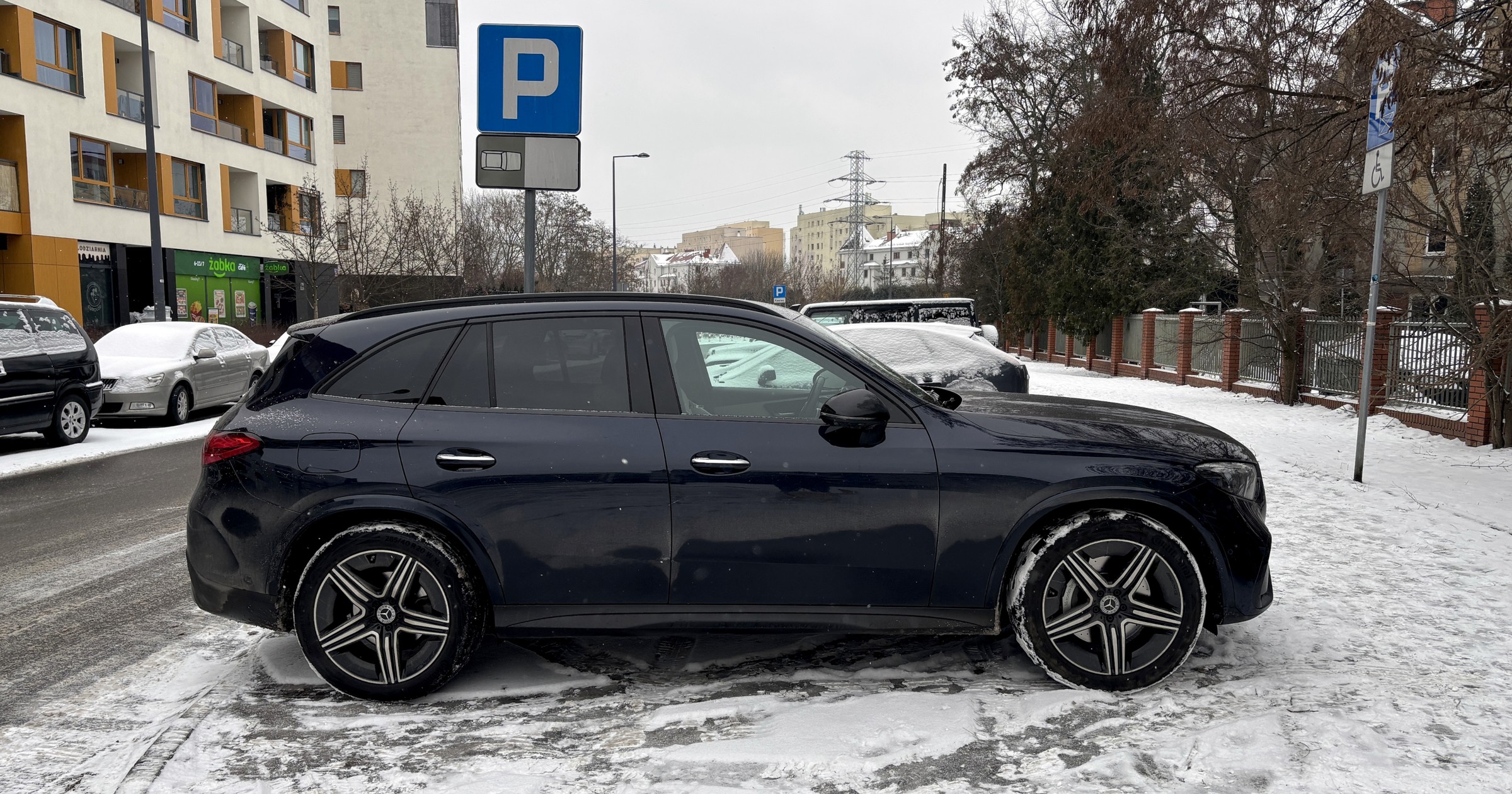 Zaparkowany samochód na zaśnieżonym trawniku