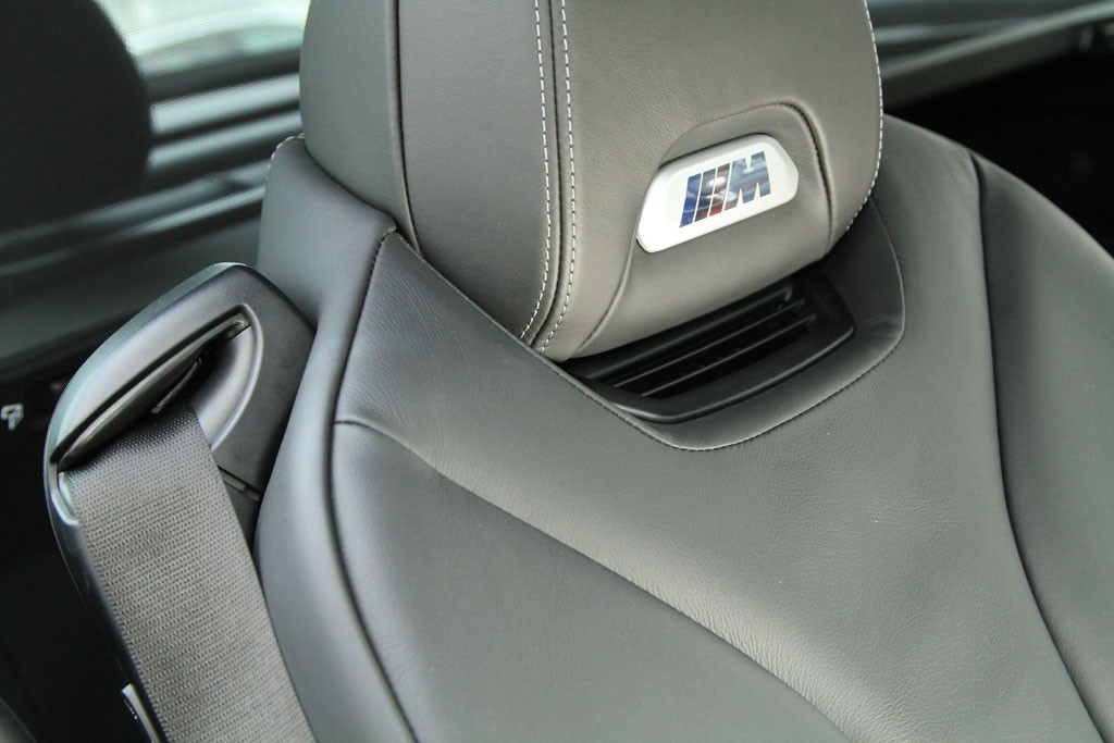 Podświetlane logo M w zagłówkach, a pod nim nawiewy ogrzewania szyi