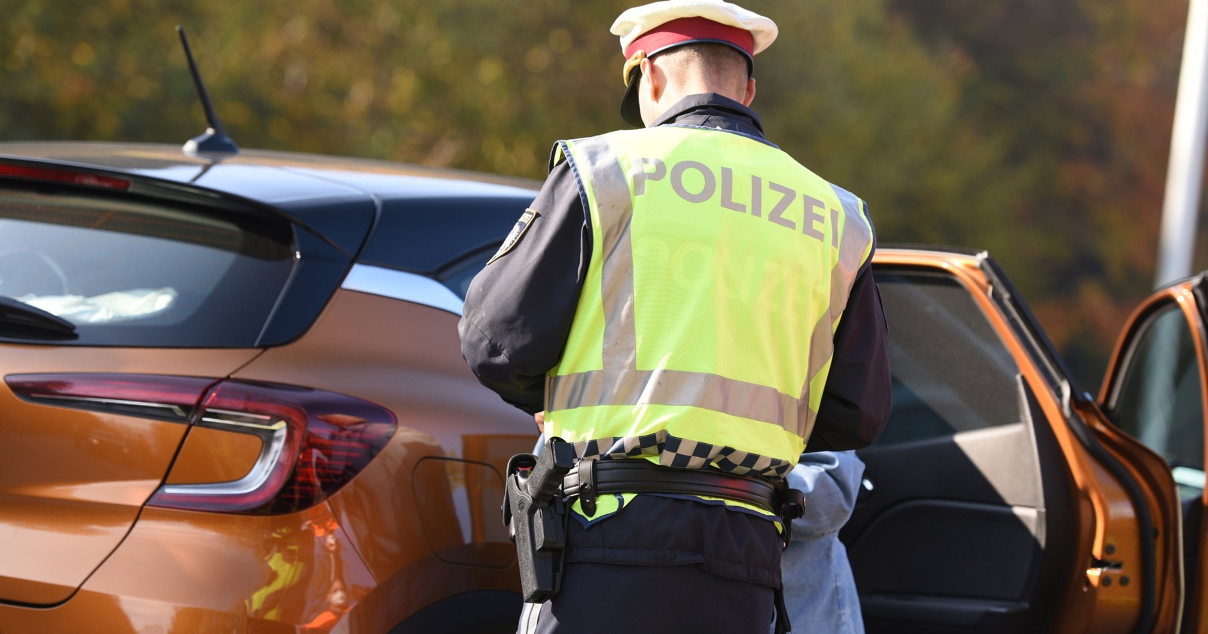 Austriacki policjant wypisujący mandat zatrzymanemu kierowcy