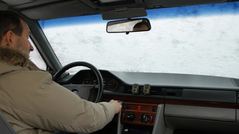 Oblodzona od wewnątrz szyba samochodu: przed rozgrzaniem silnika kierowca nie ma szans na bezpieczną jazdę - po odskrobaniu lodu na szybie natychmiast osadza się szron.