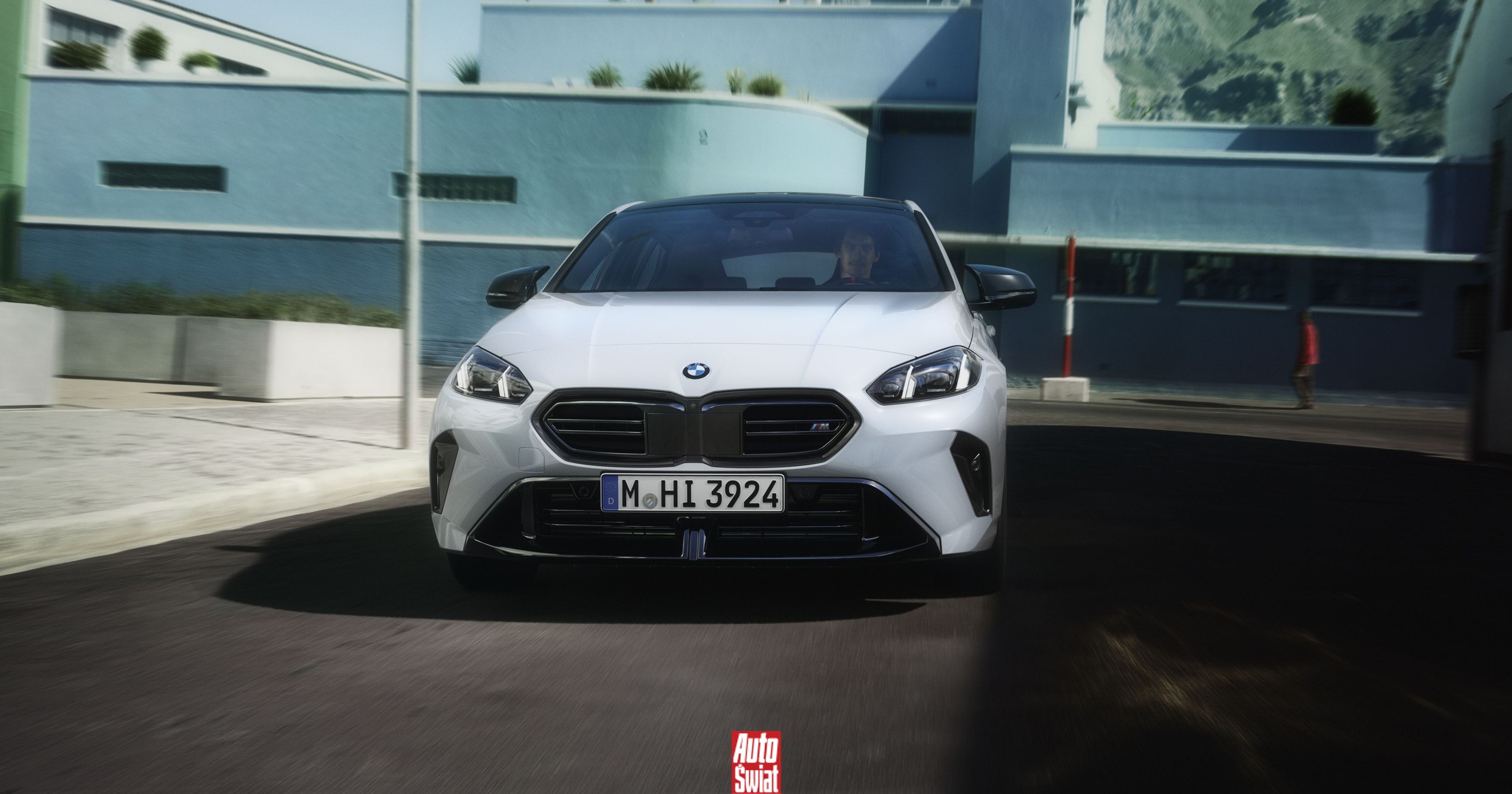 BMW Serie 1 con display digitale e tecnologia ibrida, in movimento su strada