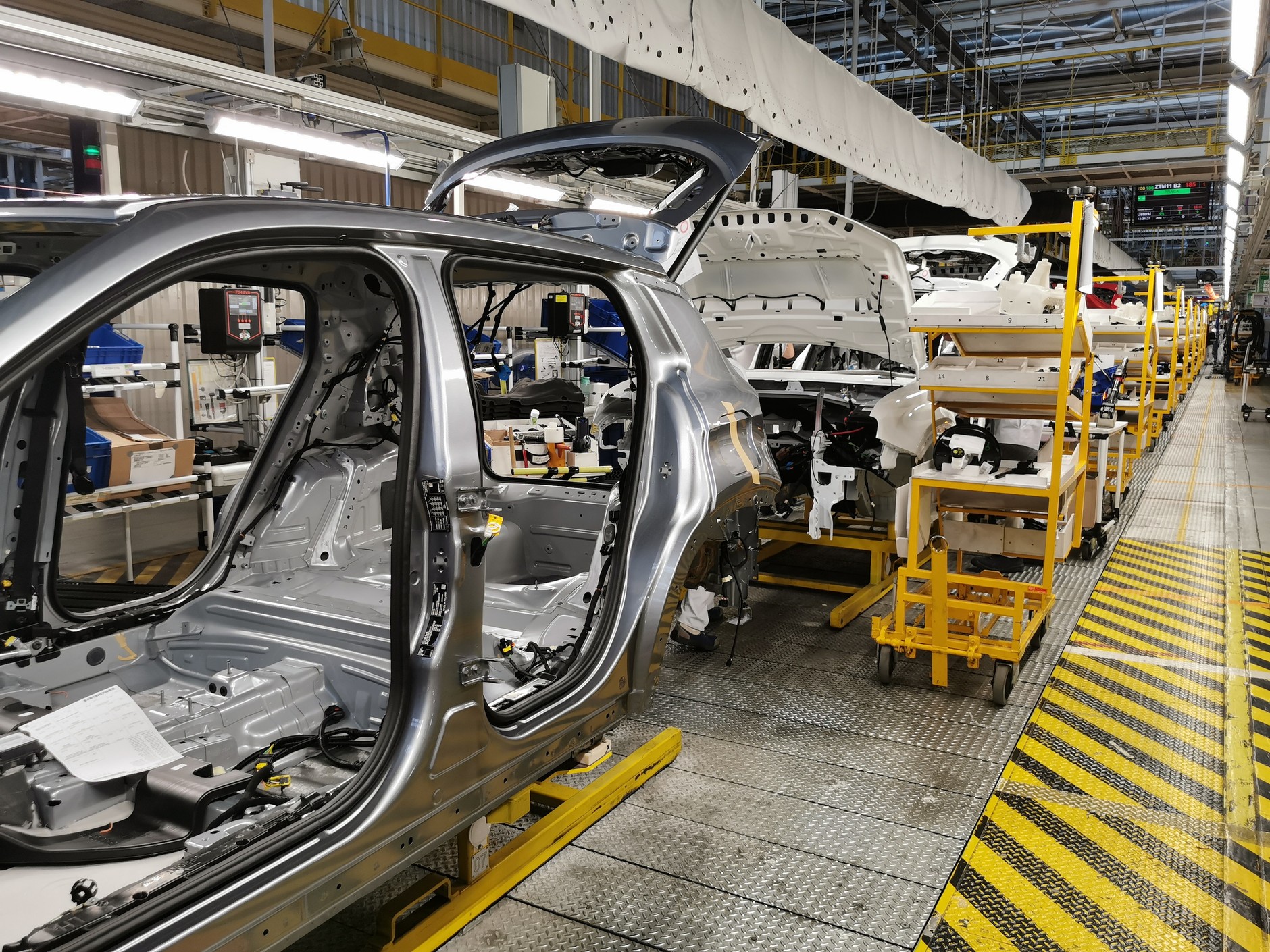 Kolejny etap: każde z nadwozi tymczasowo "rozbrojonych"  z drzwi ma przyporządkowany wózek z zestawem części, które trzeba do niego zamocować. Na tym etapie szkielety samochodów mają już numer VIN i zaczynają się coraz bardziej różnić pomiędzy sobą, także w obrębie tego samego modelu – w zależności od wersji wyposażeniowej, kolorystycznej, zamówionych przez docelowego klienta opcji, itp.