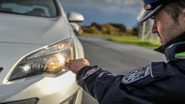 Policjant sprawdza światła podczas kontroli drogowej