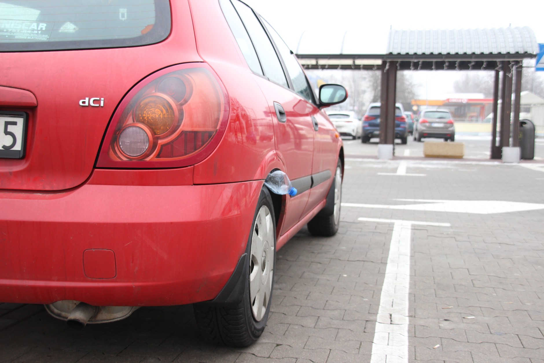 Butelka włożona między oponę i nadkole