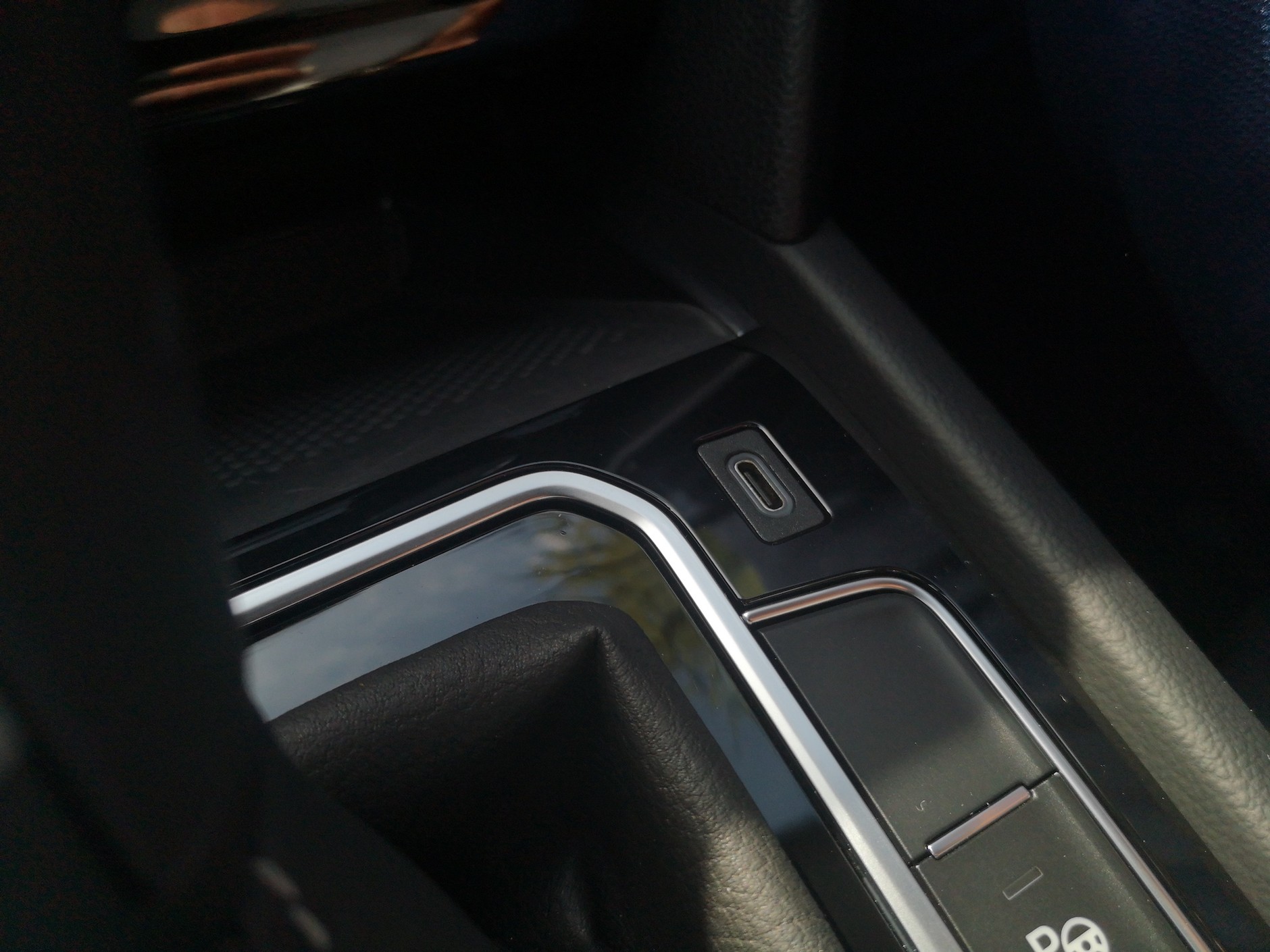 Gniazdo USB (teraz nowoczesny typ: USB-C) z wnęki powędrowało na tunel środkowy przy lewarku. Wygospodarowano w ten sposób miejsce na większy, współczesny telefon. Oczywiście płytka na telefon może mieć ładowanie indukcyjne