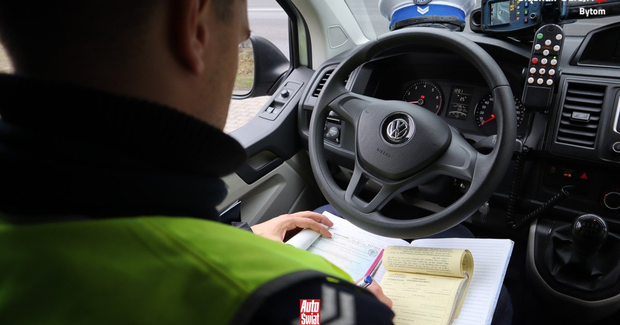 Un conducente che guarda il telefono mentre guida, con un'auto e un cartellino multa. Scenario stradale con rischio