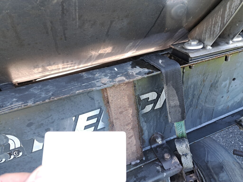 Koło zapasowe przymocowane pasem transportowym i pospawana rama naczepy