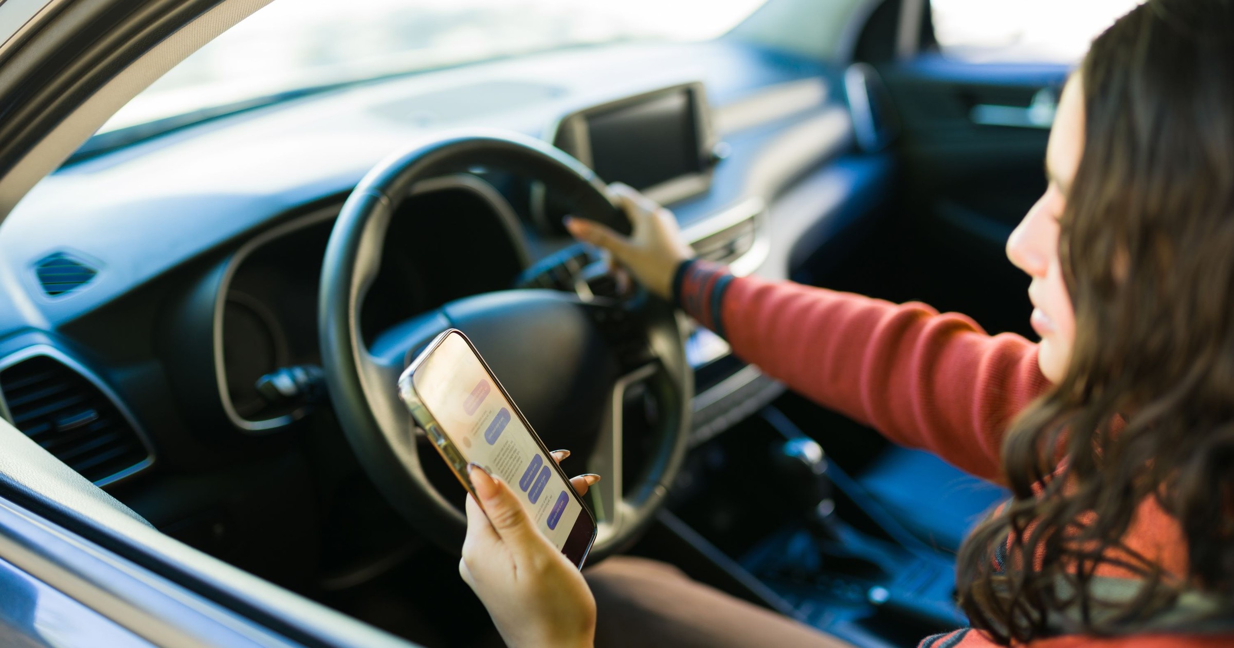 Kierowca ze smartfonem (zdjęcie ilustracyjne)