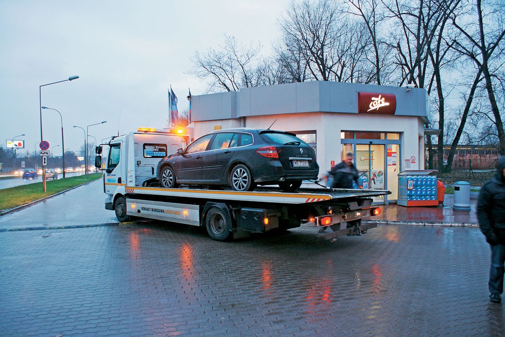 Samochód na lawecie odjeżdża spod stacji benzynowej – zdjęcie ilustracyjne