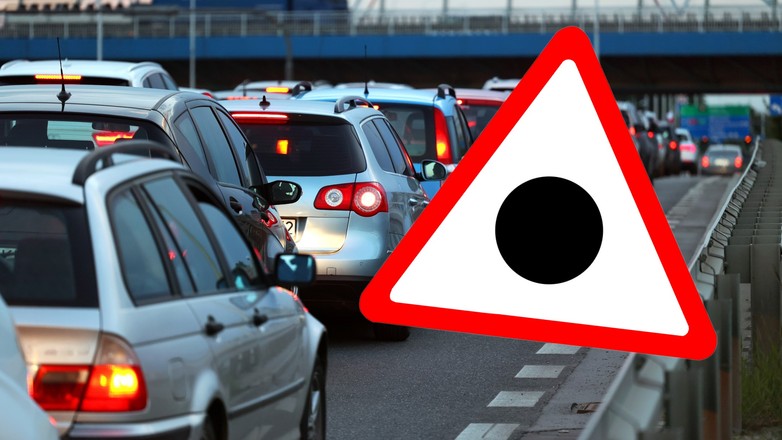 Znak drogowy przedstawiający czarną kropkę wpisaną w trójkąt ostrzegawczy