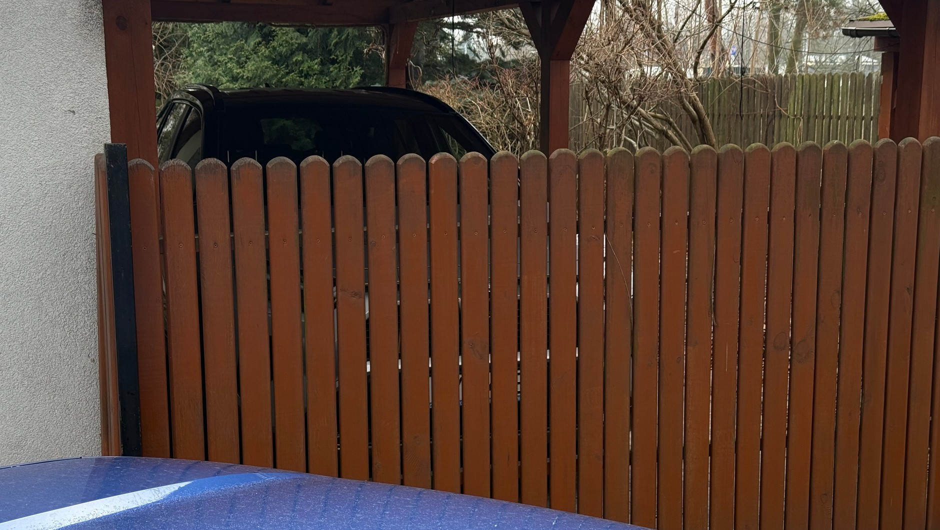 Samochód za płotem na zamkniętej posesji