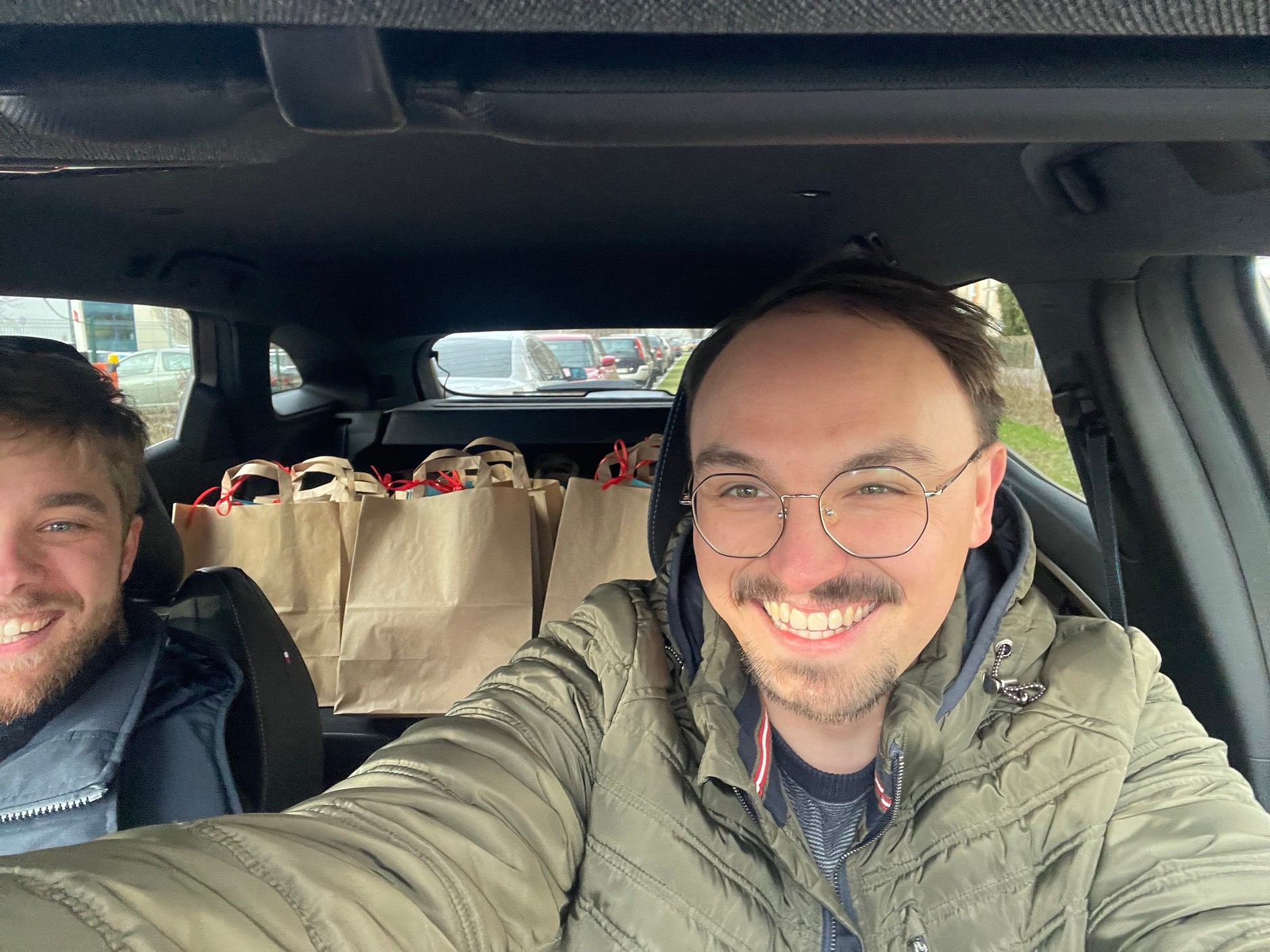 W pierwszym rzędzie dwóch wolontariuszy, z tyłu podarunki