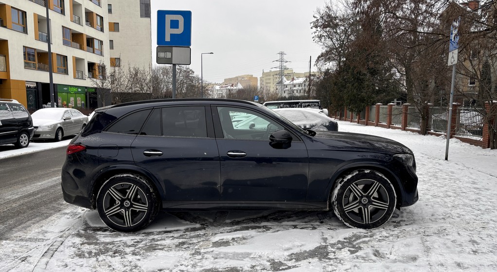 Zaparkowany samochód na zaśnieżonym trawniku