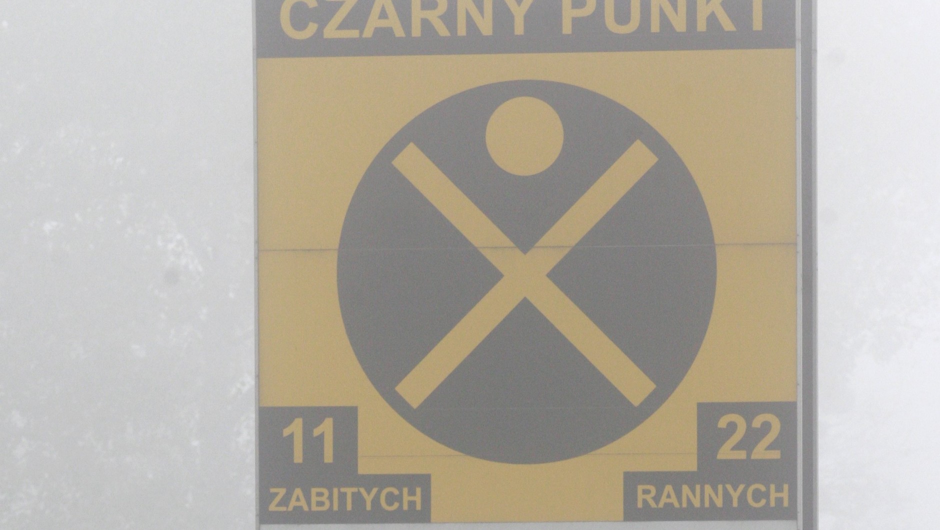Zasłonięta przez mgłę polska tablica oznaczająca "czarny punkt"
