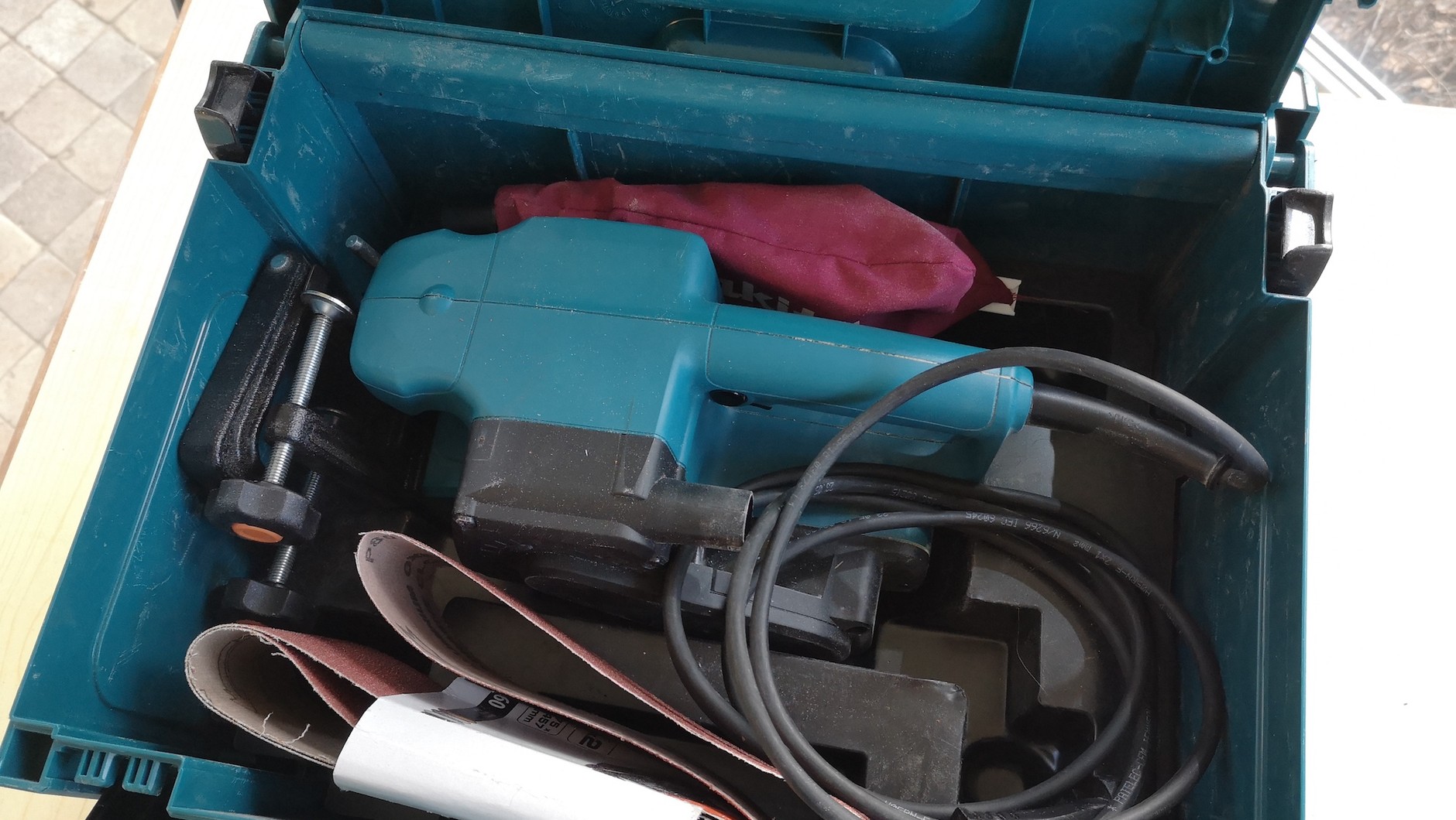 Kuferek transportowy jest o tyle ważny, że szlifierka już po pierwszym użyciu jest brudna i zapylona, w dodatku towarzyszą jej papiery ścierne i akcesoria