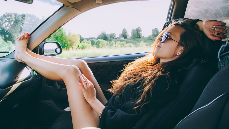 Nogi na desce rozdzielczej samochodu