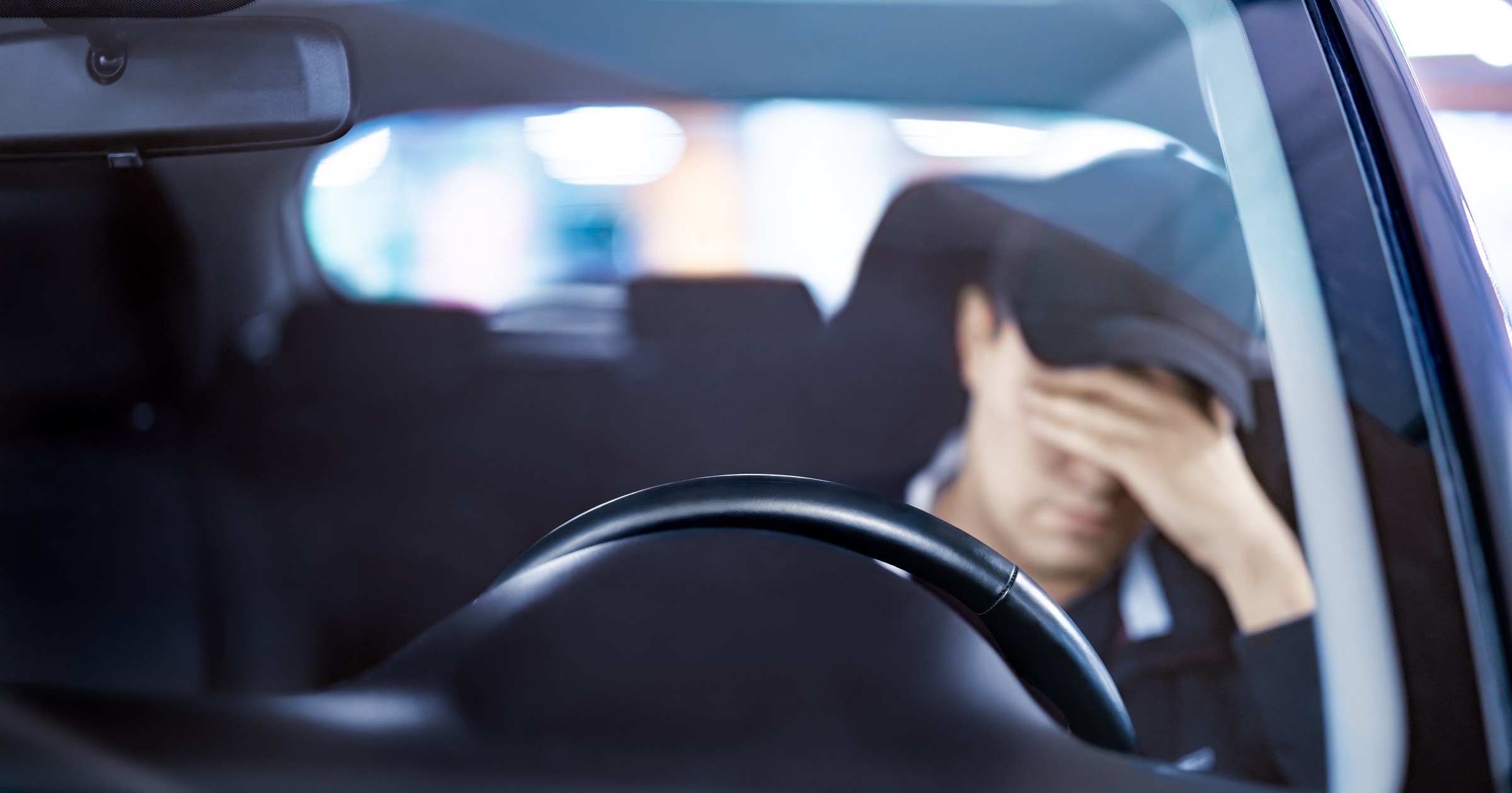 Zmęczony kierowca w samochodzie (zdjęcie ilustracyjne)