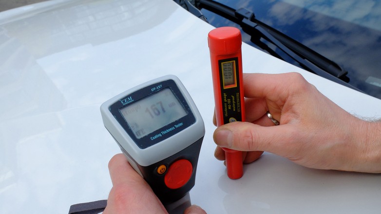 Dwa różne mierniki i... rzadko identyczny wynik!  w tym przypadku różnica wynika z faktu, iż maska samochodu wykonana jest z aluminium, a czerwony miernik na zdjęciu nie działa na aluminium i zwyczajnie „nie widzi” blachy.  Tanie mierniki w ogóle nie są idealnie dokładne