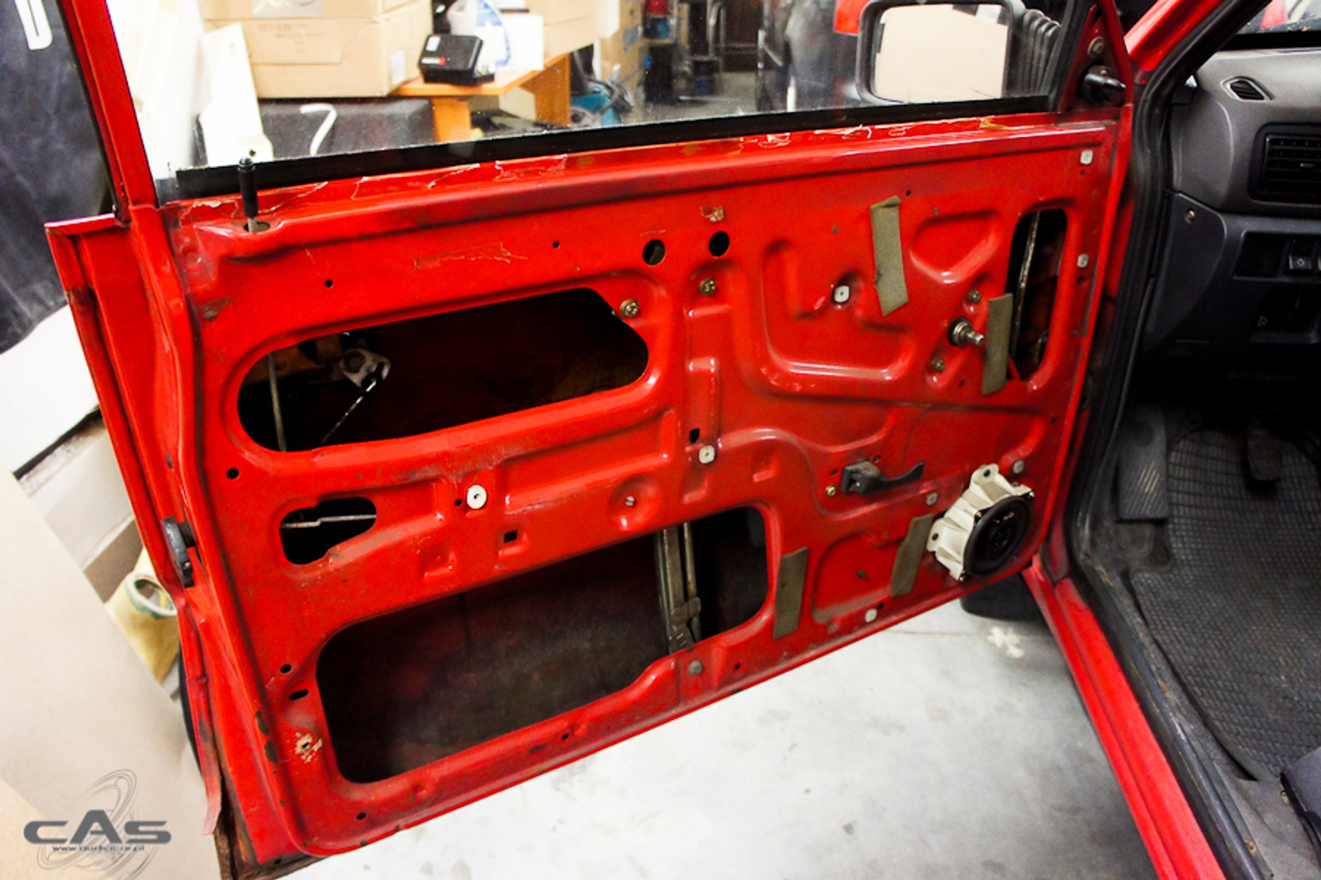 Drzwi z widocznym głośnikiem w fabrycznym plastikowym kołnierzu.